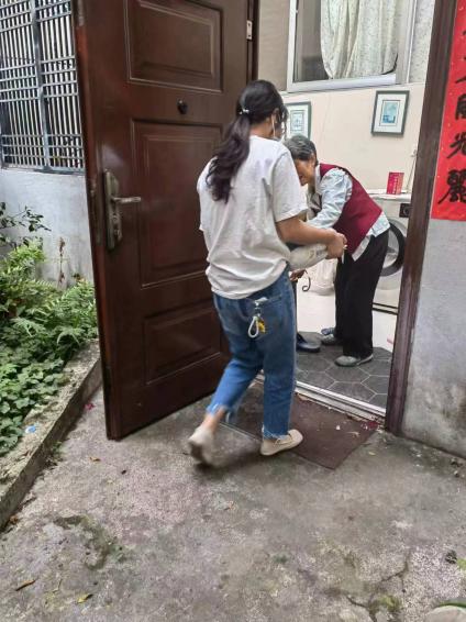 说明: 9.12志愿者为老年人送东西